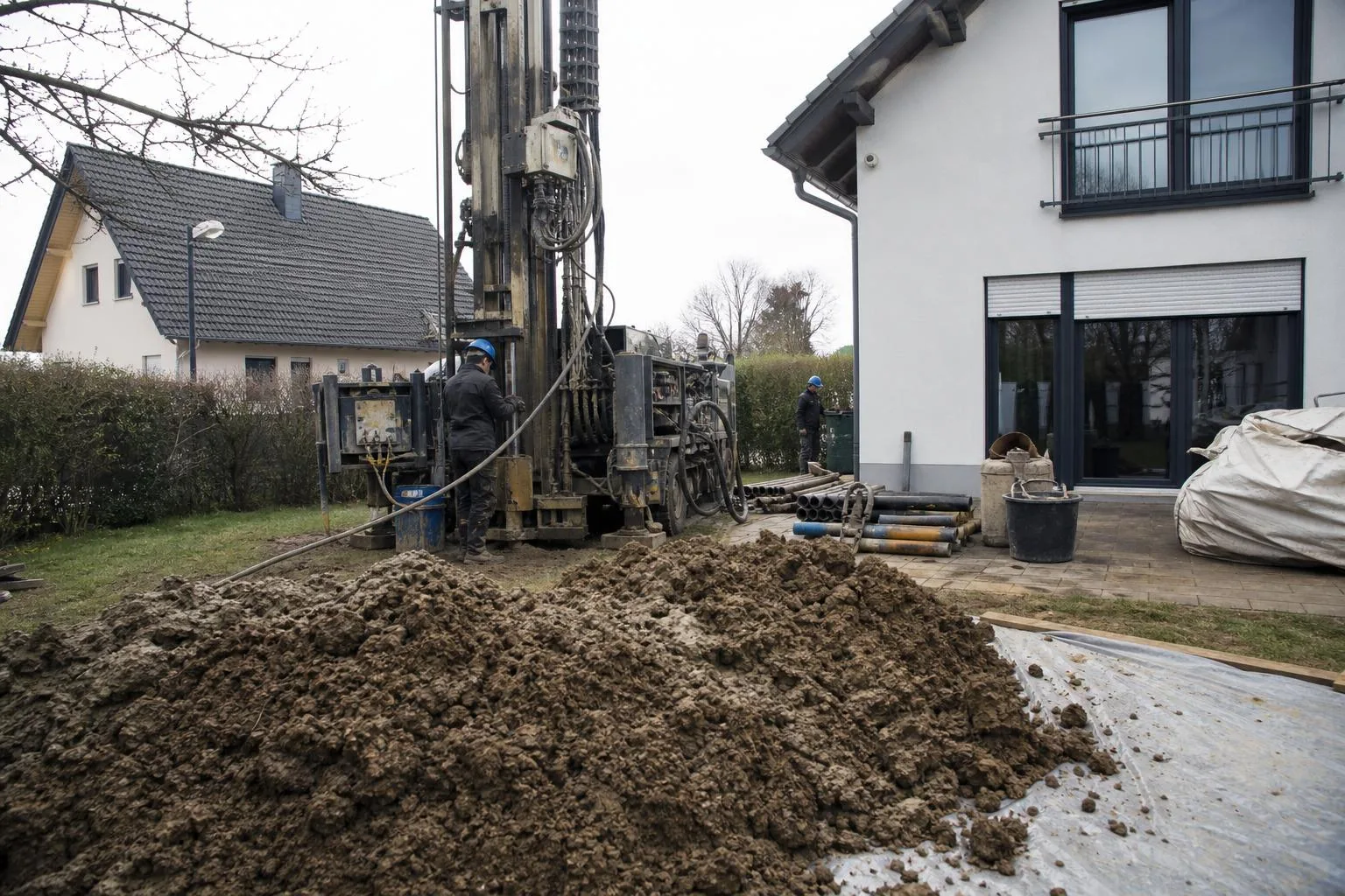 Erdwärmepumpe Installation: Bohrgerät beim Setzen einer Erdsonde im Garten eines Einfamilienhauses in Deutschland